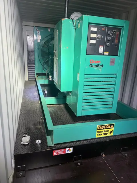 Green Cummins Onan diesel genset installed inside its container.