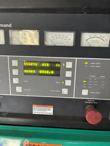 Cummins PowerCommand control panel with analogue meters, digital display and emergency stop.
