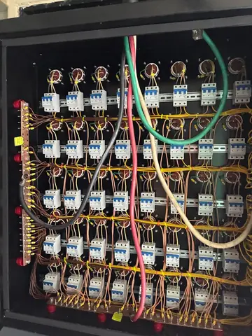 Rows of circuit breakers with labelled wiring behind the receptacle panel.