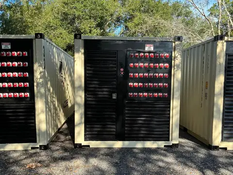 Three JD Power Packs generator containers in the yard, each with a bank of red 480 V reefer receptacles.